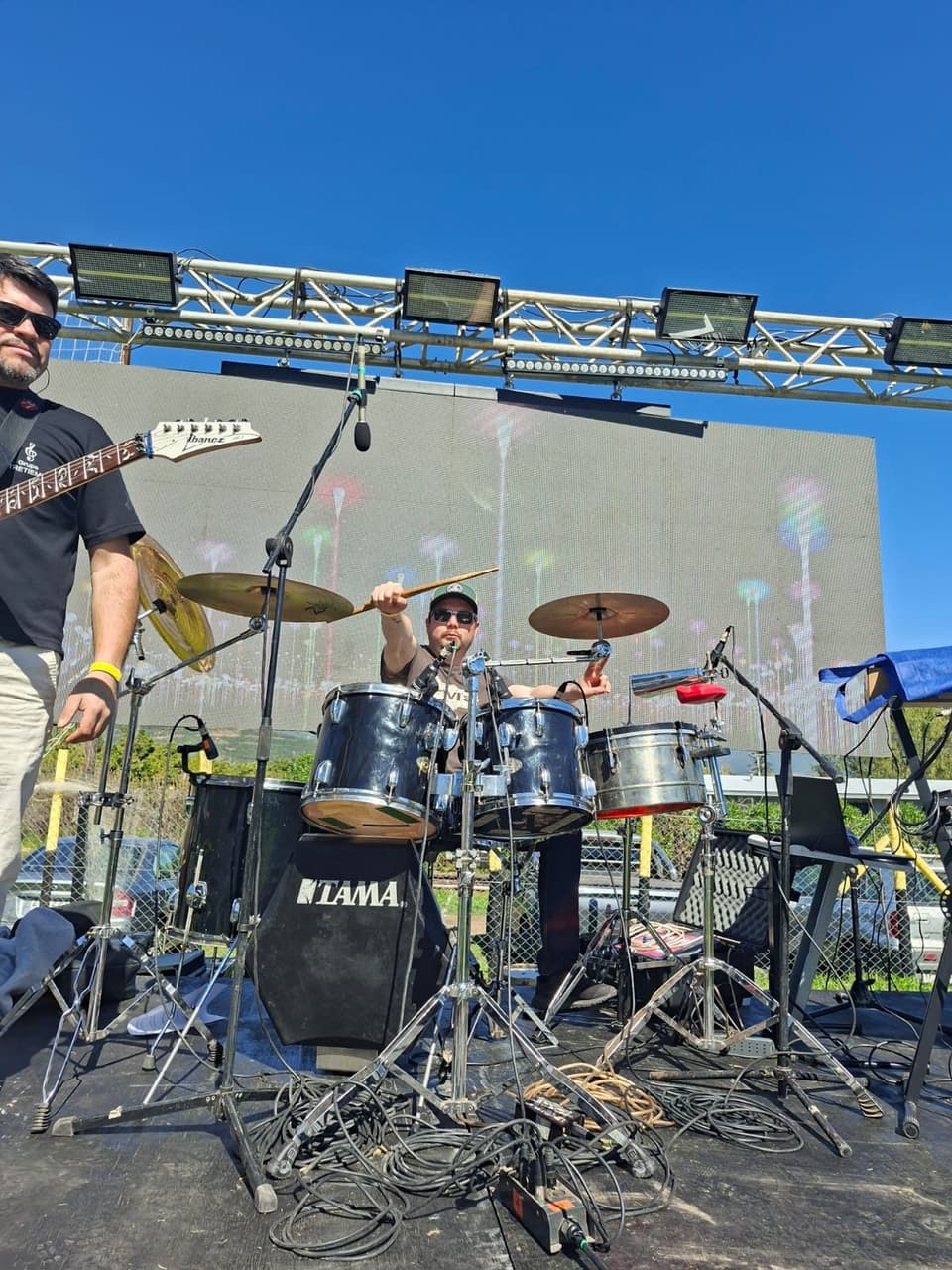 Baterista de Entretiempos tocando una batería Tama en un escenario al aire libre